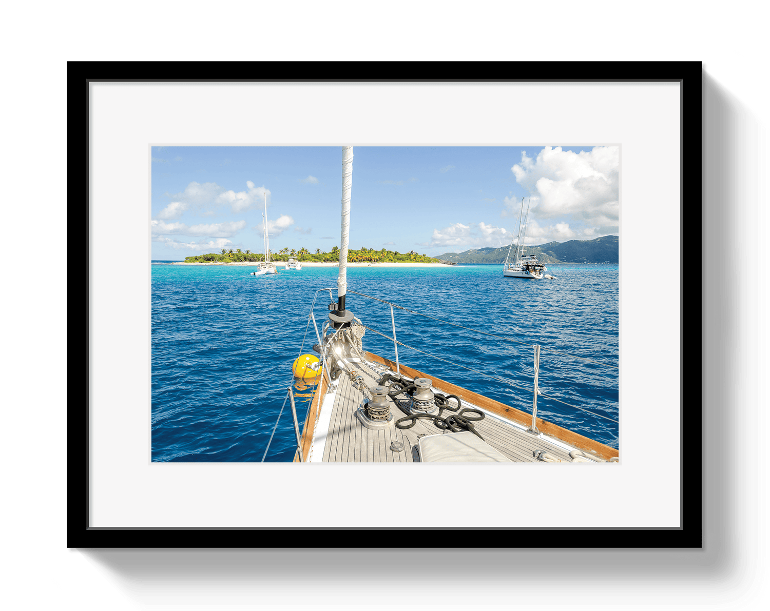 Framed photograph of a sailboat on a clear day with blue water and white clouds.