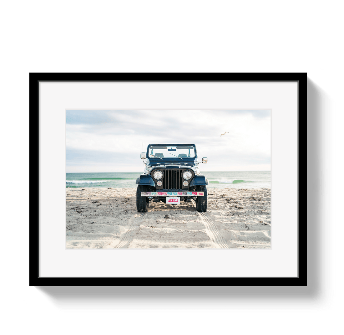 Framed photo of a blue jeep on a beach