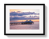 Framed photograph of a pier at sunset with a colorful sky.