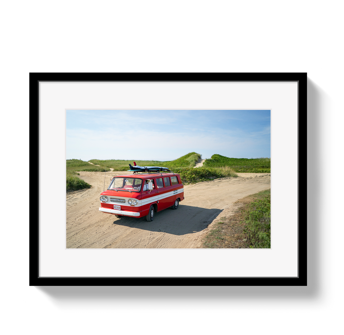 Framed photograph of a red van with a surfboard on a beach path