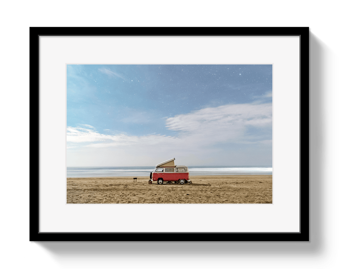 Framed photograph of a red van with a surfboard on a beach