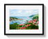 Framed artwork of a coastal town with red roofs and a harbor.
