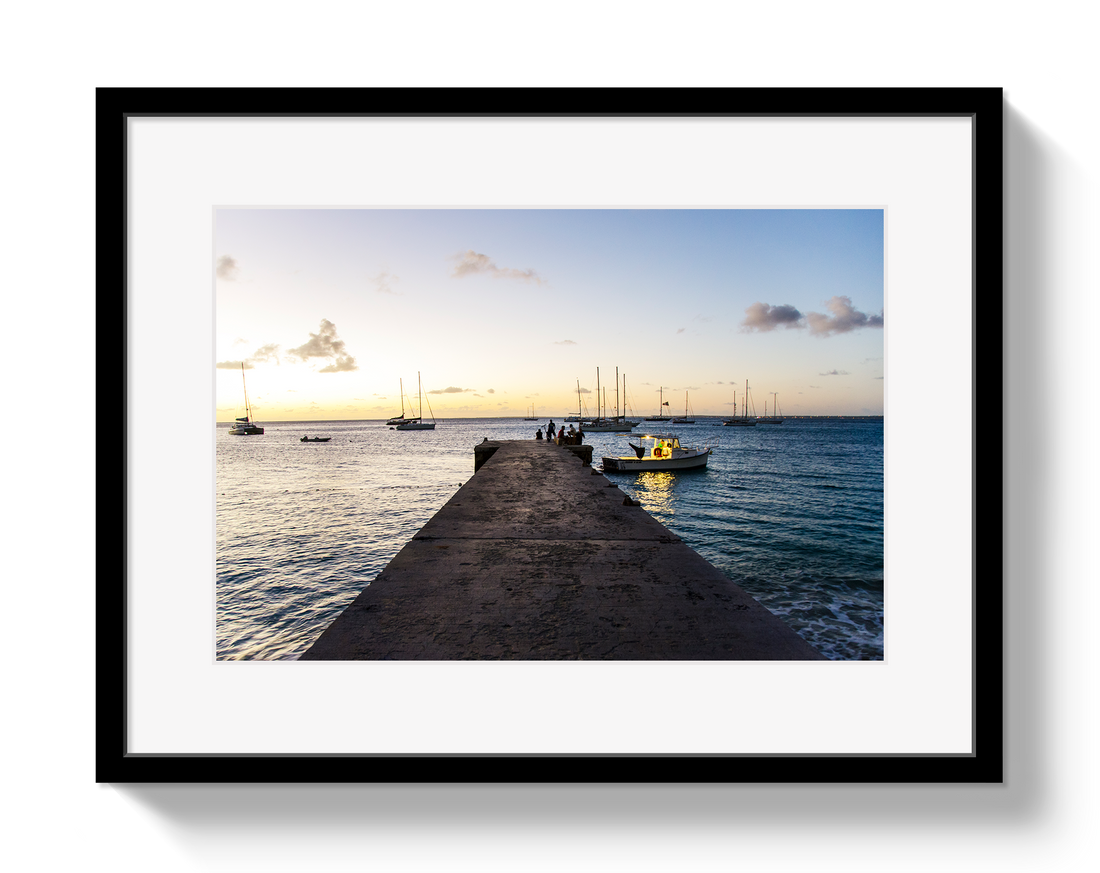 Framed photograph of a dock with boats at sunset.