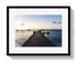 Framed photograph of a dock with boats at sunset.