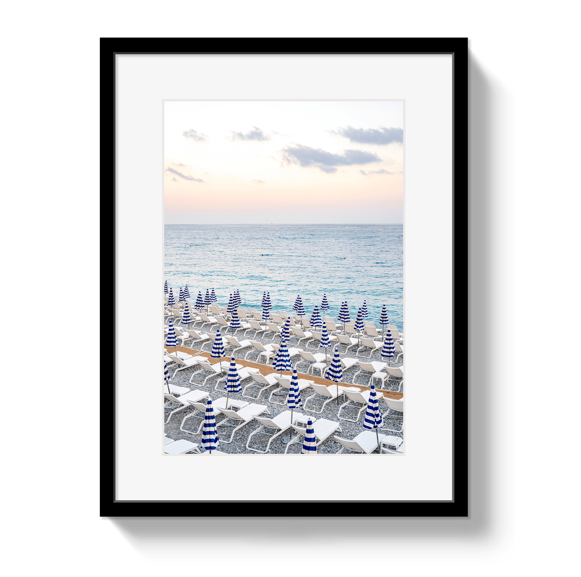 Framed artwork of a beach scene with striped umbrellas and ocean view.
