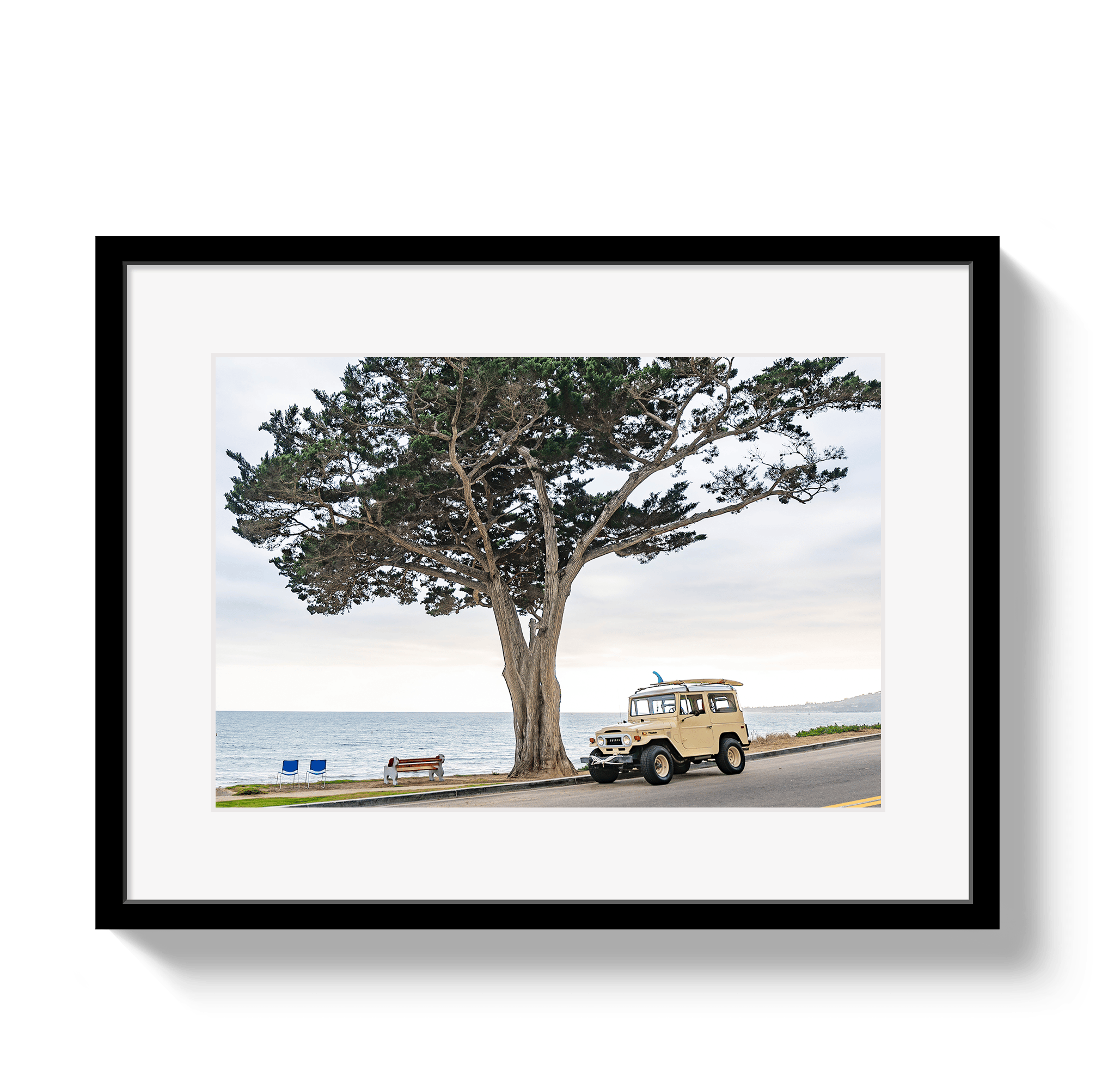 Framed artwork of a vintage car by a tree with ocean view