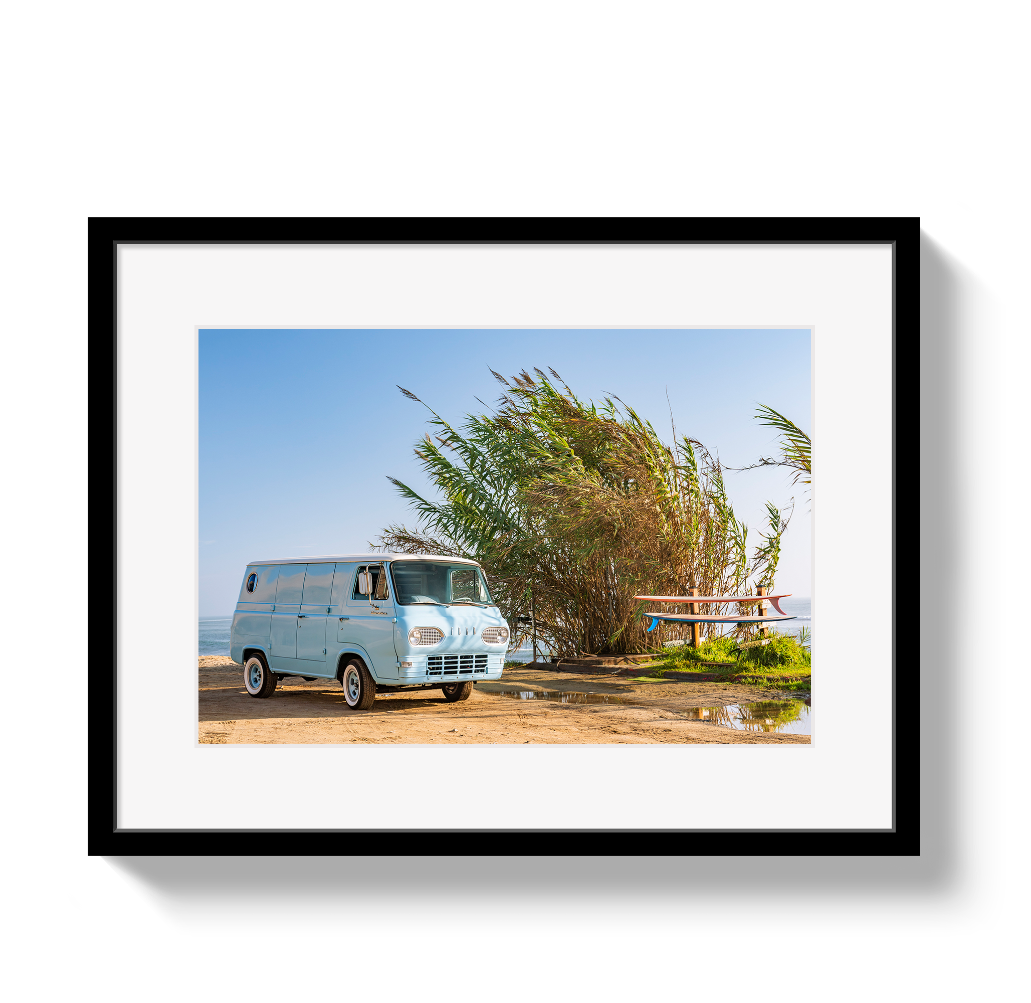 Framed photograph of a vintage van parked near tall grasses with a clear blue sky.