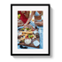 Framed photo of a picnic with food and two people sitting on a blanket.