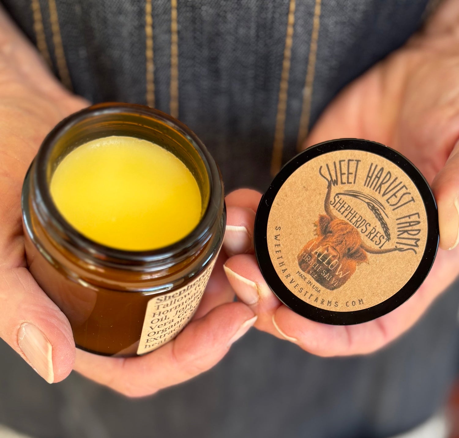 Jar of yellow substance held by hands with &