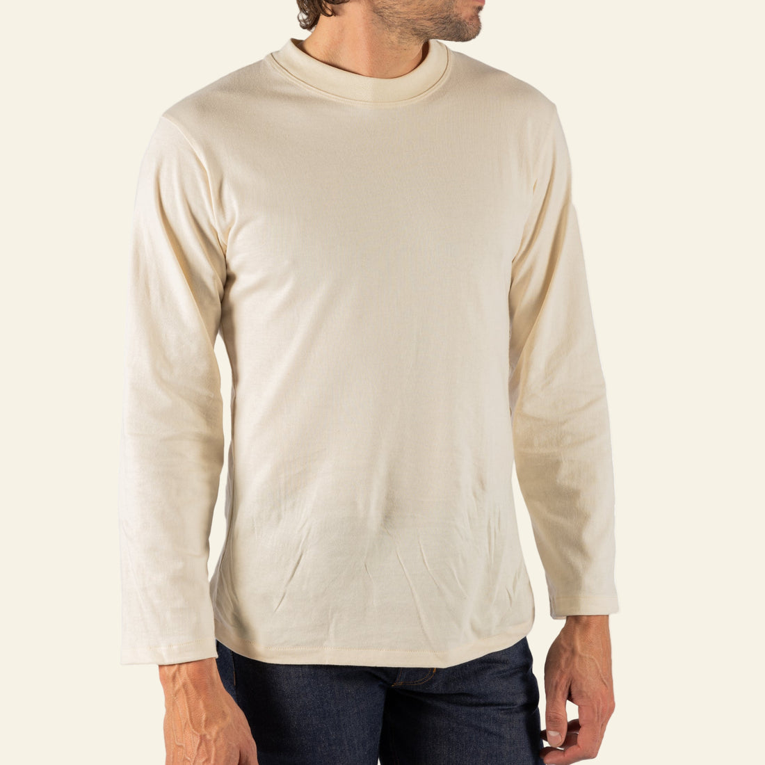 Man wearing a beige long-sleeve shirt on a white background