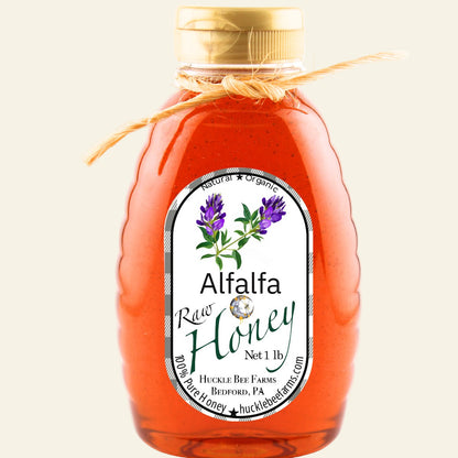 Bottle of alfalfa honey with a label on a white background