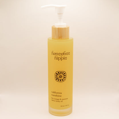 Yellow bottle of honeybee hippie California Sunshine body oil on a beige background