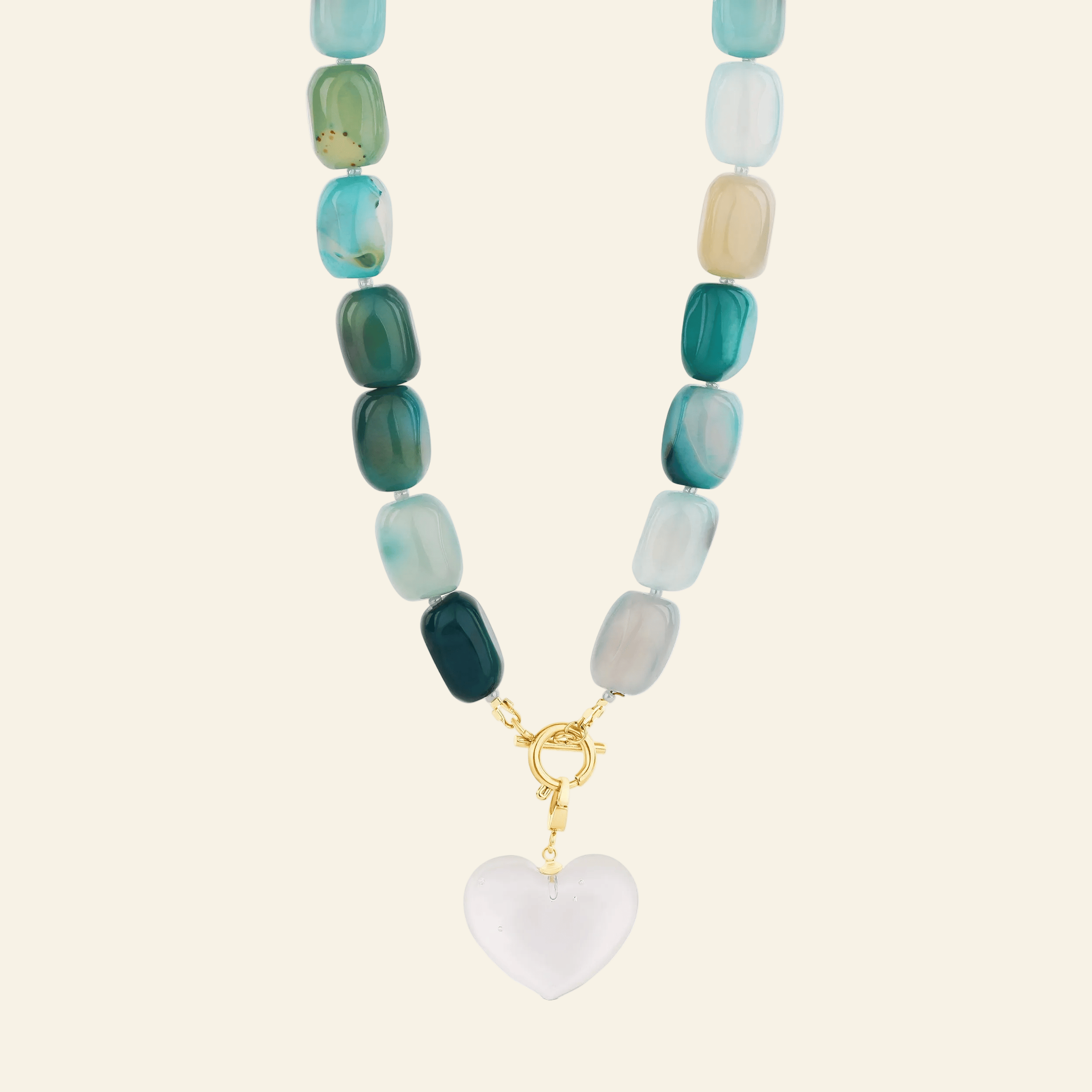 Necklace with green and blue beads and a heart-shaped pendant on a white background