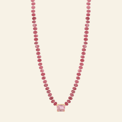 Necklace with pink beads and a pink pendant on a white background