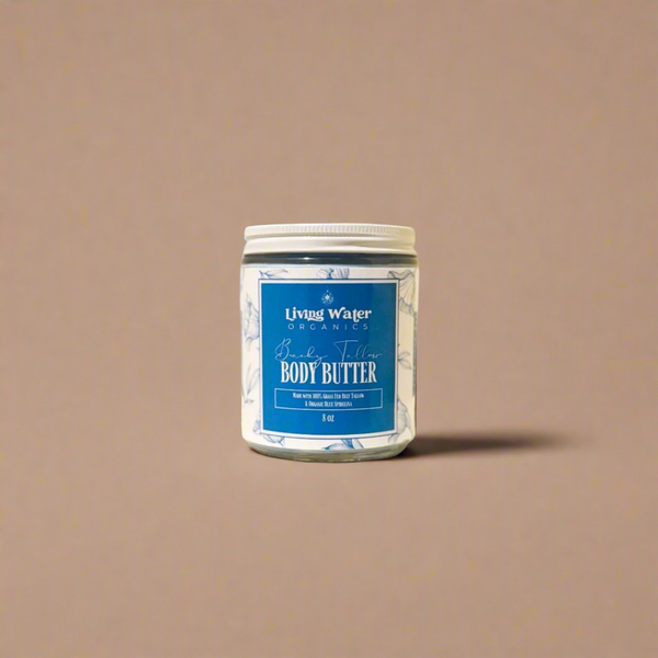 Jar of body butter with a blue label on a beige background