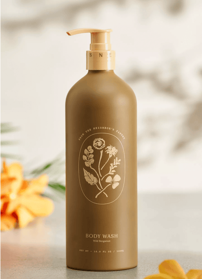 Brown body wash bottle with floral design on a blurred natural background