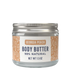 A 1.5 oz glass jar of Georgia Peach Body Butter with a silver metal lid and a white label featuring peach-colored patterns.