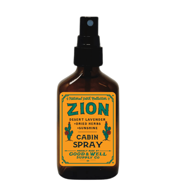 An amber glass spray bottle with a black spray top and a yellow label reading &