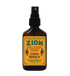 An amber glass spray bottle with a black spray top and a yellow label reading &