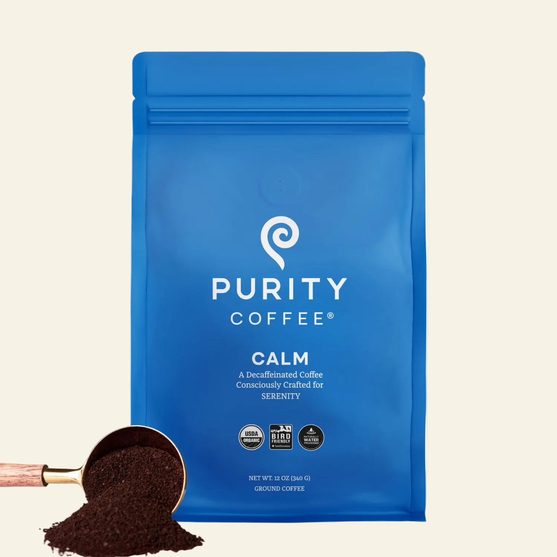 Blue bag of Purity Coffee with a scoop of ground coffee on a white background