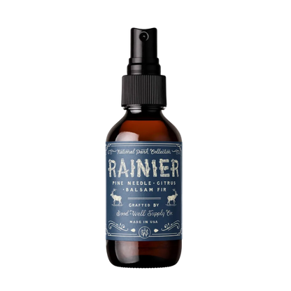An amber glass spray bottle with a black pump dispenser and a dark blue label reading &
