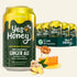 A 12-pack of Yes Honey Bee Original Ginger Ale cans arranged in front of a large single can, with ginger roots, honeycomb, and a honey dipper on a white background.