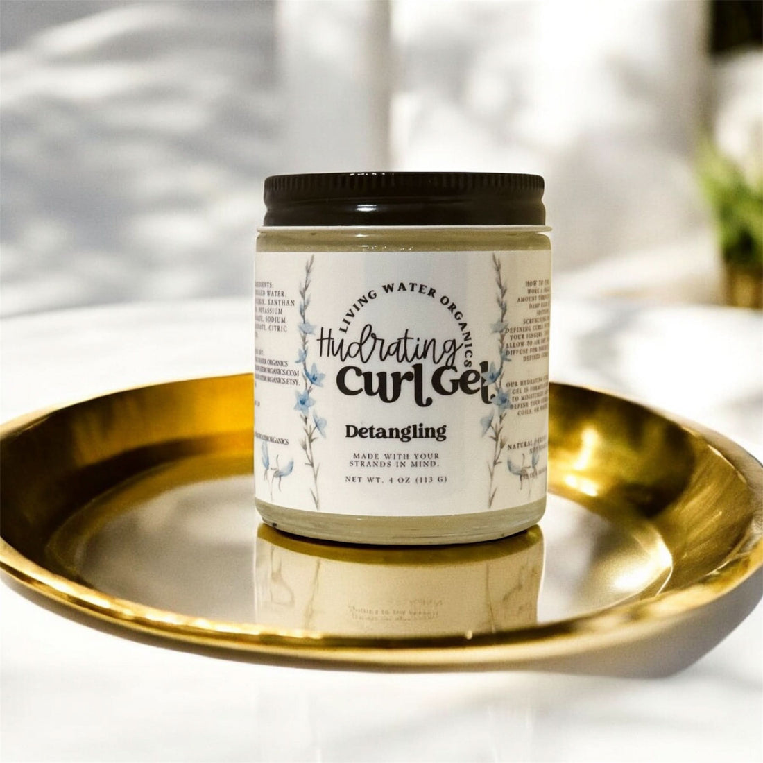 Jar of hydrating curl gel on a gold tray with a blurred background