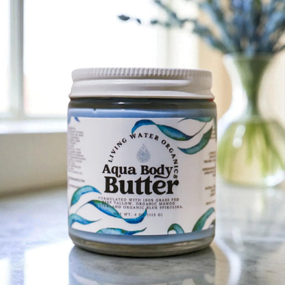 Jar of Aqua Body Butter on a marble surface with a blurred background