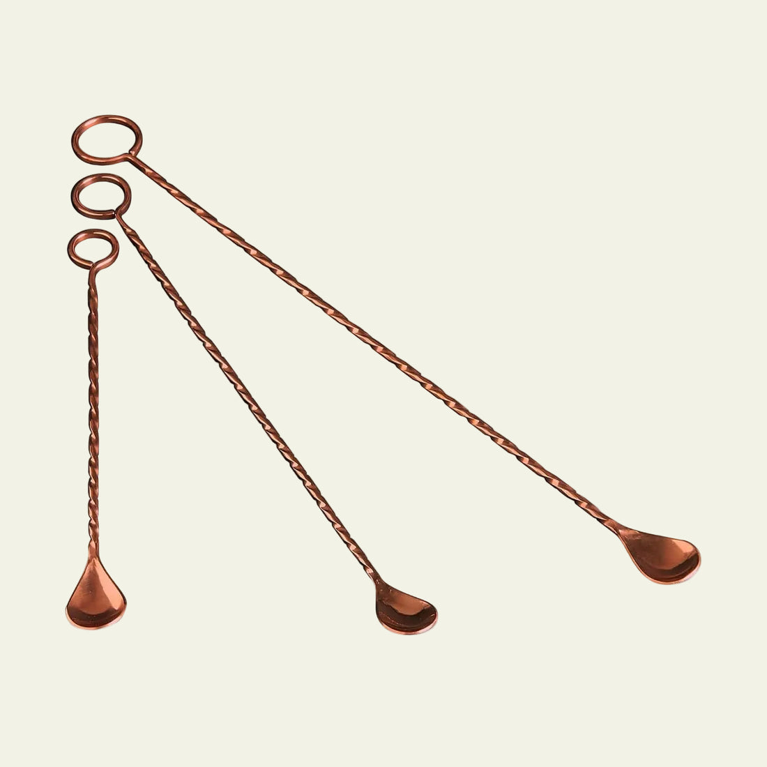 Set of four copper muddlers on a white background