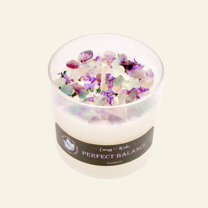Candle with colorful crystals and a label on a white background
