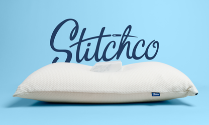 White pillow with Stitchco branding on a blue background