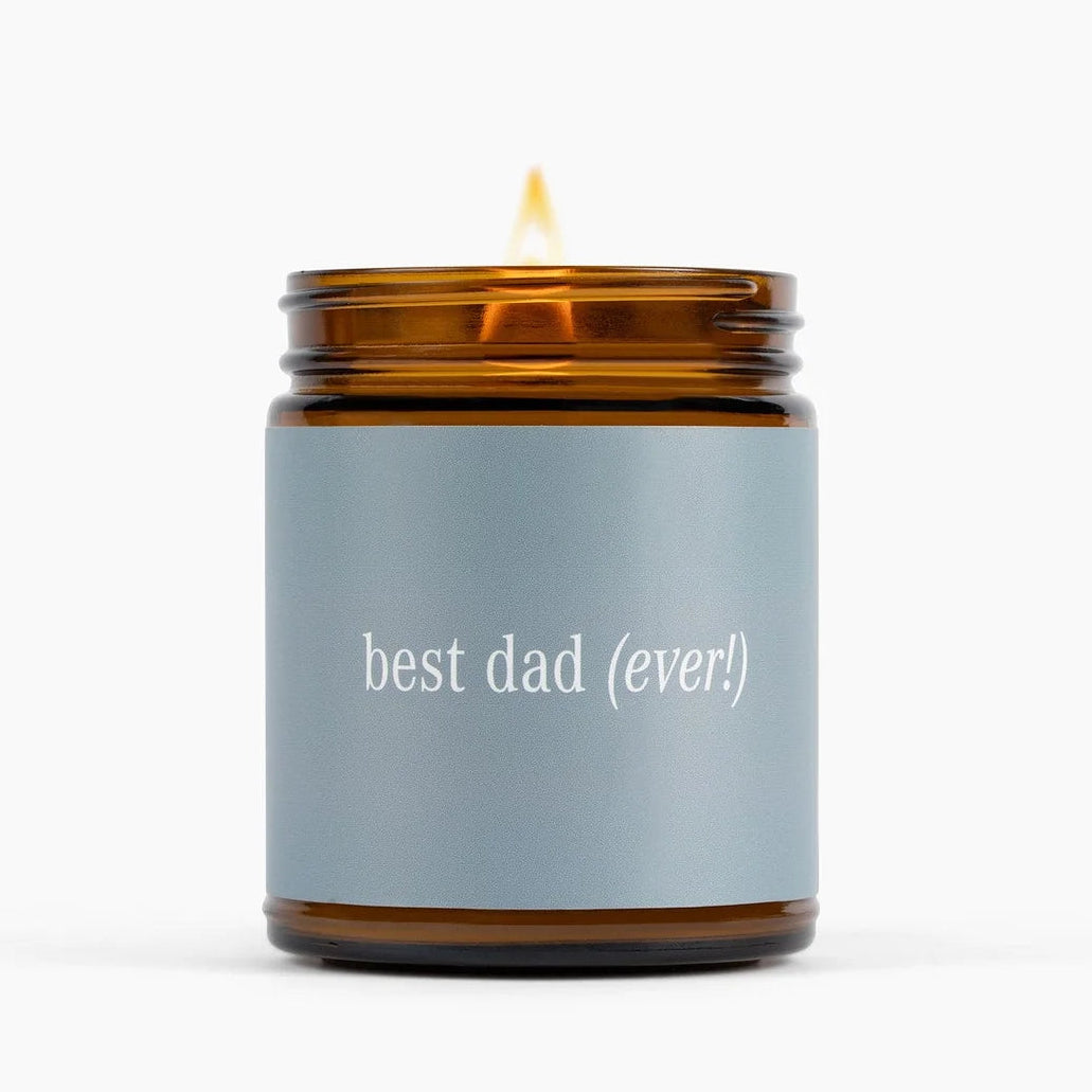 Candle in an amber jar with a gray label saying &
