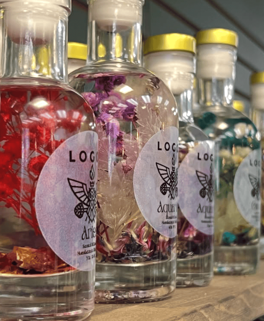 Bottles of Logos Artisanal Aromatique with visible labels on a wooden surface.