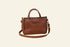 Brown leather handbag with a strap on a white background
