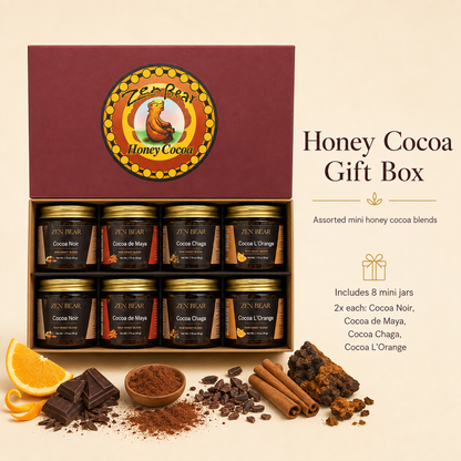 Zen Bear Honey Cocoa Gift Box containing 8 assorted mini jars of cocoa powder blends, displayed on a warm beige background with chocolate pieces, cinnamon sticks, and orange slices.