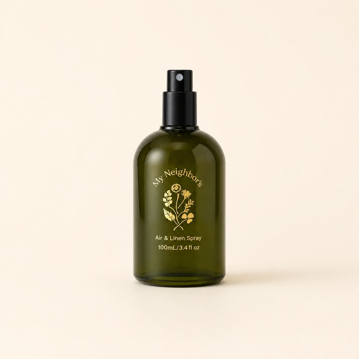 An olive green glass spray bottle with a black pump dispenser, featuring gold foil branding that reads &