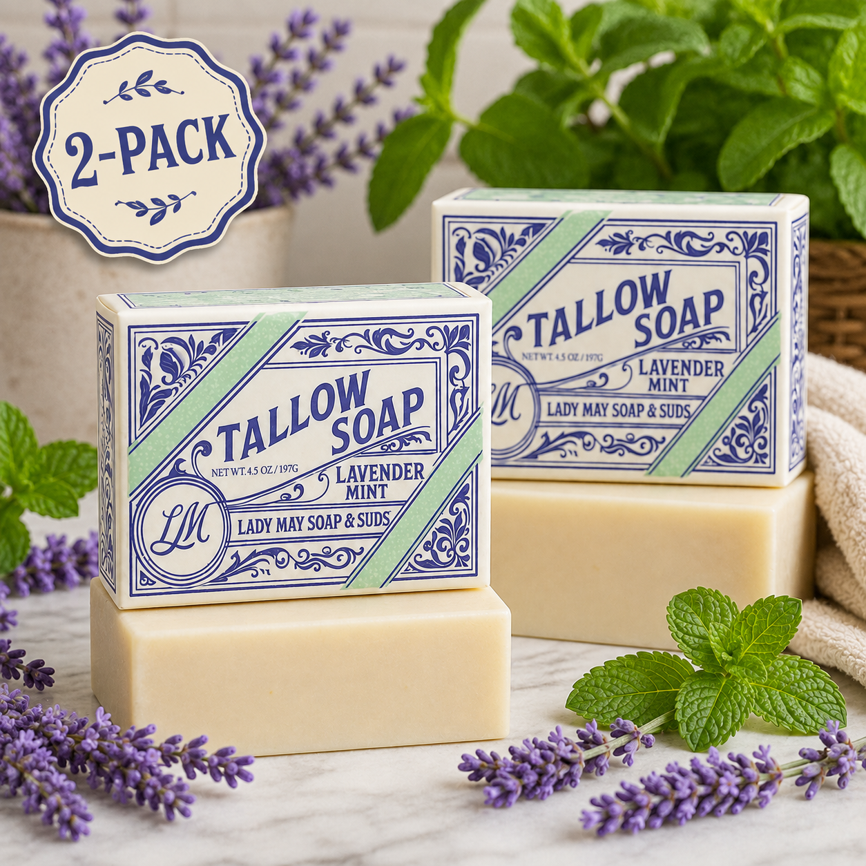 Two bars of Tallow Soap displayed in decorative boxes with lavender sprigs and mint leaves on a marble surface. A &