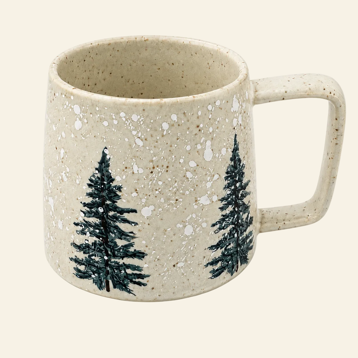 A speckled beige ceramic mug with a rounded shape, a large handle, and two dark green pine tree illustrations on the front, set against a solid cream background.
