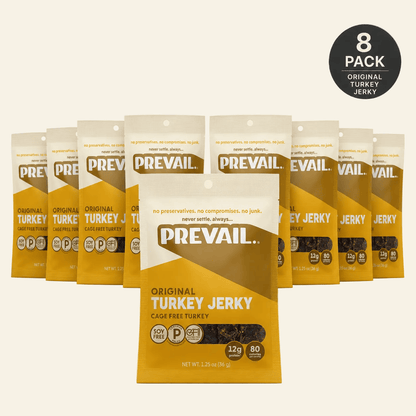 Eight bags of Prevail Original Turkey Jerky arranged in a row, with one bag in front and a black circular &