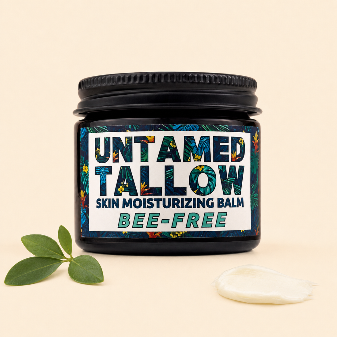 A jar of Untamed Tallow Skin Moisturizing Balm with a black lid and a tropical patterned label, shown on a beige background with green leaves and a dollop of white balm.