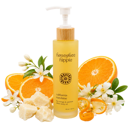 Honeybee Happee bottle of California Sunshine body oil with oranges and flowers on a white background