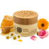 Jar of honey hydrate with wooden lid, honeycomb, flowers, and honey dipper on a white background