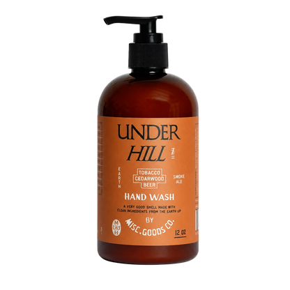 Brown bottle of Under Hill hand wash with pump on a white background