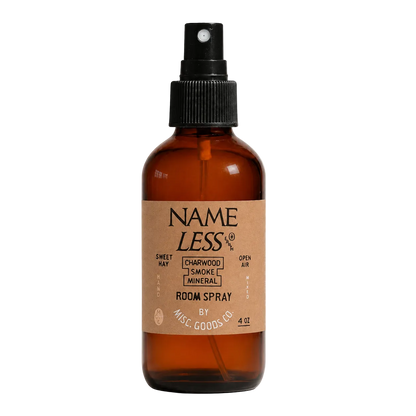 Brown glass room spray bottle with a cardboard label on a white background
