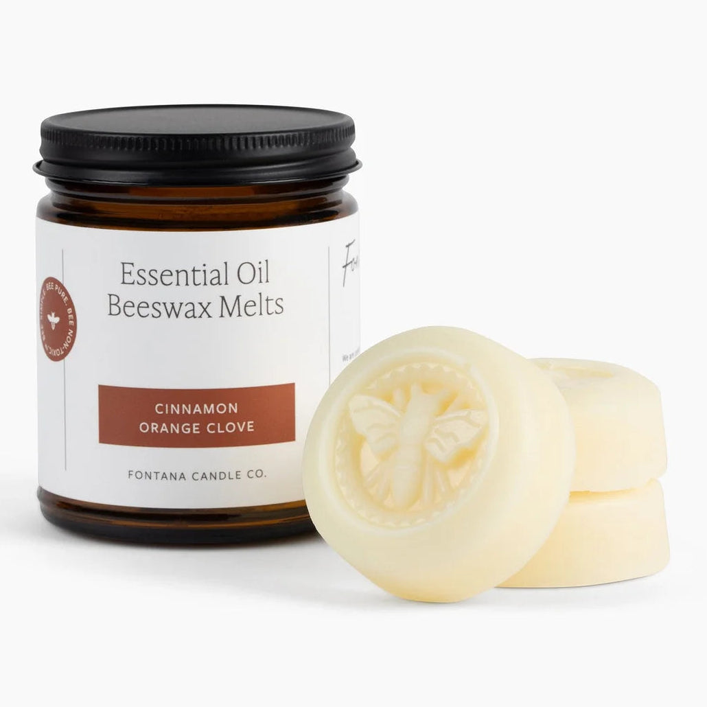 Jar of essential oil beeswax melts with two melts on a white background