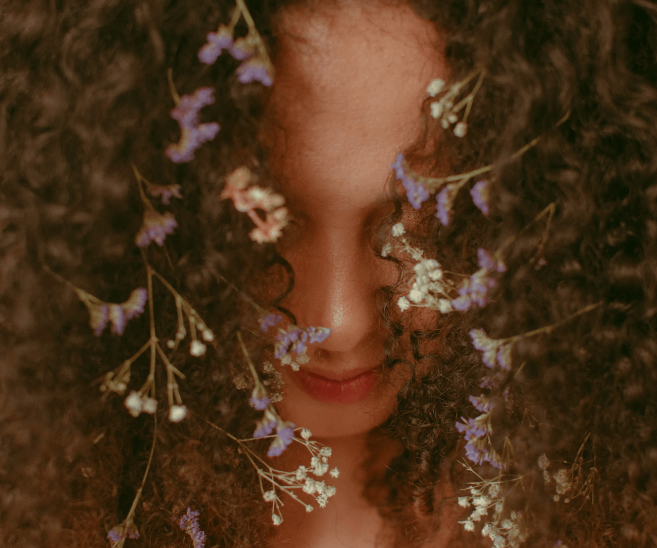 Close-up of a person with flowers intertwined in their hair