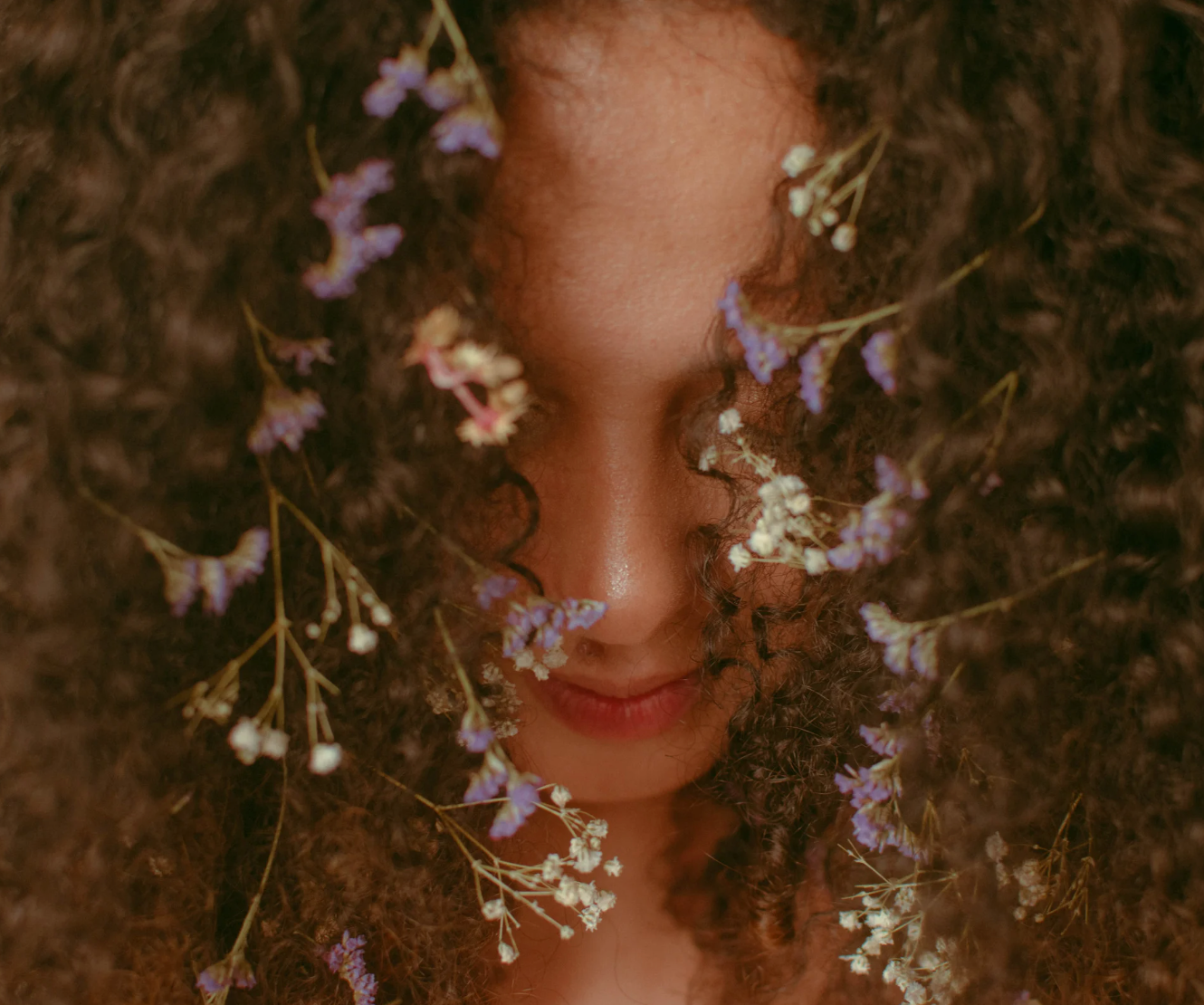 Close-up of a person with flowers intertwined in their hair