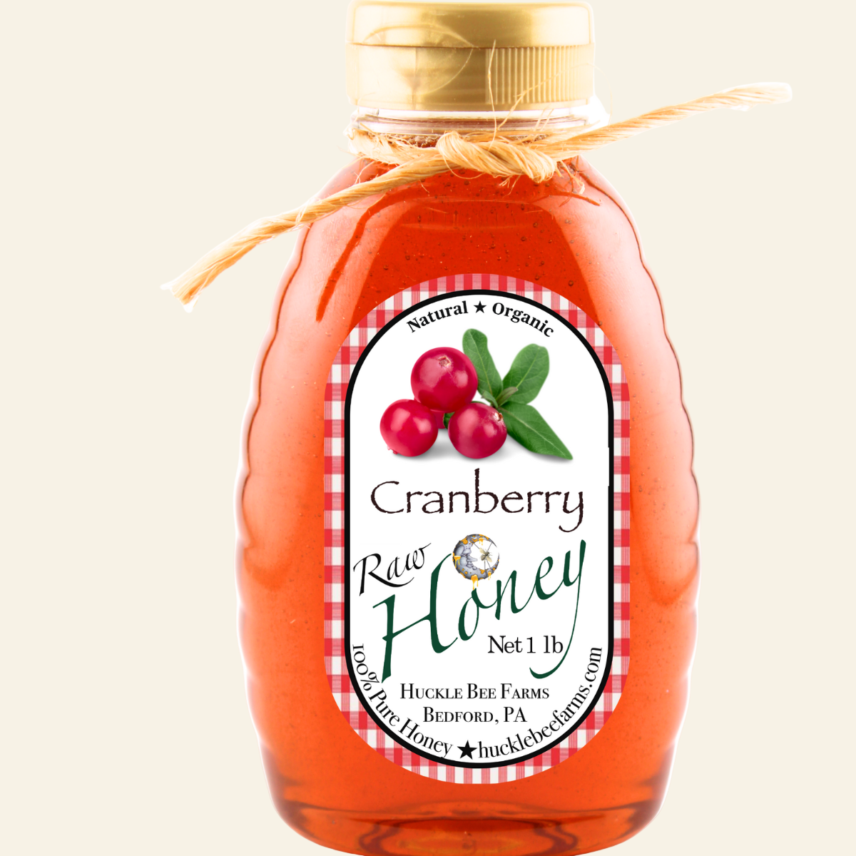 Bottle of cranberry raw honey with a label on a white background