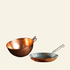 Two copper cookware items on a wooden surface with a dark background