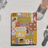 Notebook with decorative cover featuring various patterns and illustrations on a light surface.